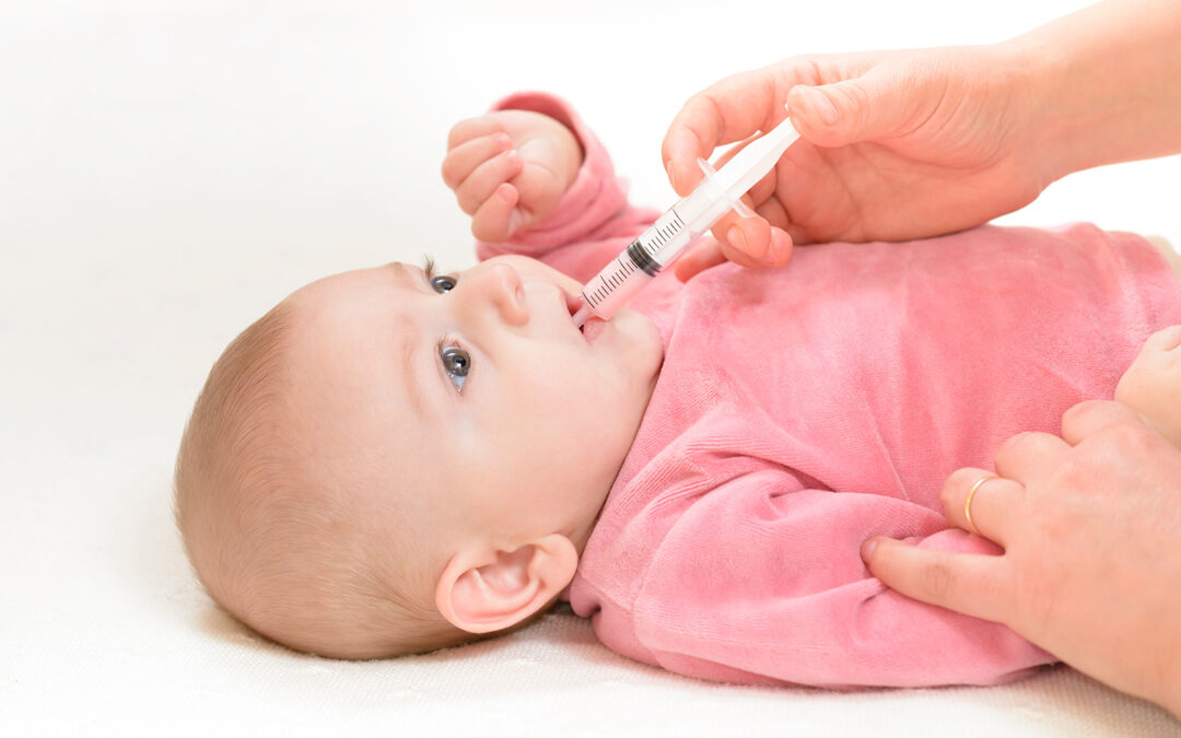 Photo of infant receiving oral medication.